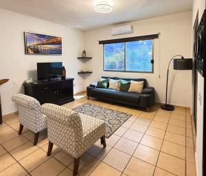 a living room with a couch and a tv at Cabo Downtown Studios in Cabo San Lucas