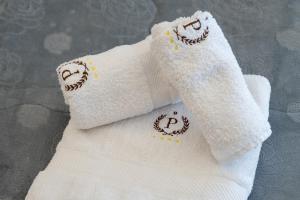 two white towels with smile faces embroidered on them at Federico 70 Rubino in Palermo +4 photos