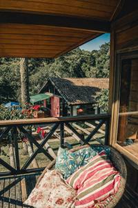 a couch on a porch with a view of a house at Chacara da Dinda in Piraquara