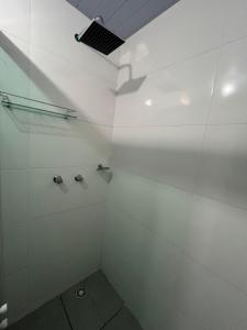 a bathroom with a shower with white walls at suítes Arco-íris in Uberlândia +13 photos