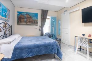 a bedroom with a blue bed and a tv at Federico 70 Rubino in Palermo