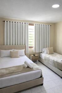 a bedroom with two beds and a window at Hotel ladymar cartagena in Cartagena de Indias +1 photo