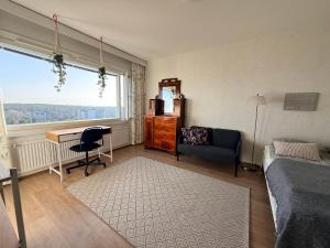 a bedroom with a desk and a bed and a window at The Treetop Apartment in Turku
