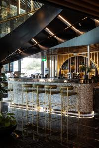 a bar in a restaurant with stools at a counter at SOHO Hotel Auckland in Auckland