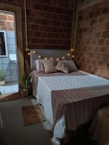 a bedroom with a bed with a brick wall at Só Alegria in Paulista
