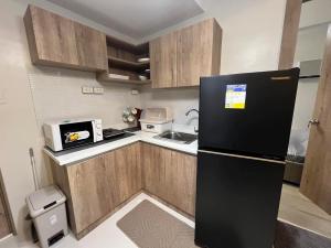a kitchen with a black refrigerator and a sink at KEY REALTY SERVICES Ph in Lapu Lapu City