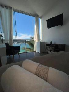 a bedroom with a bed and a view of the ocean at Pousada Mirante do Atalaia Oficial II in Arraial do Cabo