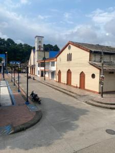 a person riding a motorcycle down a street next to a building at Hotel SR, Villa Garzón in Villagarzón