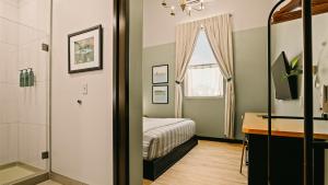 a bedroom with a bed and a desk and a mirror at Violet Inn, Lounge & Spa in Two Rivers