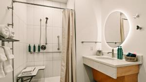 a white bathroom with a sink and a shower at Violet Inn, Lounge & Spa in Two Rivers +21 photos