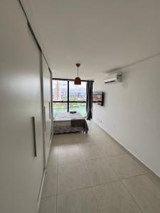an empty room with a bed and a window at Flat luxo vista pro açude in Campina Grande