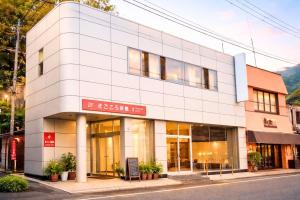 a white building with a sign in front of it at Magokoro House 203 in Nishiizu