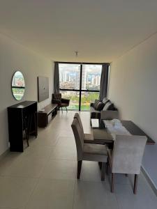 a living room with a table and chairs and a television at Flat luxo vista pro açude in Campina Grande