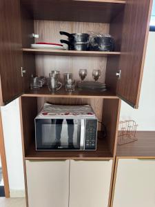 a kitchen with a microwave oven in a cabinet at Flat luxo vista pro açude in Campina Grande +10 photos