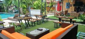 an outdoor patio with tables and chairs and a pool at Dewi Sri Guesthouse in Mataram