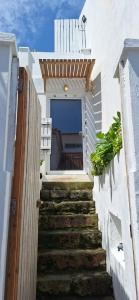 a stairway leading up to a white building with a patio at Daniel in Lagoa