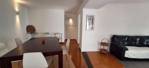 a living room with a table and a leather couch at Daniel in Lagoa