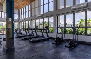 a gym with a row of treadmills and windows at ON Smart Lofts - 3 min a pé da Oktoberfest com cama Queen in Blumenau