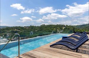 a balcony with a swimming pool on top of a building at ON Smart Lofts - 3 min a pé da Oktoberfest com cama Queen in Blumenau
