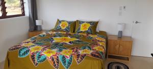 a bedroom with a bed with a colorful bedspread at Reureu Ocean Vistas in Arutanga
