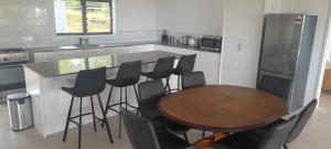 a kitchen with a wooden table and black chairs at Reureu Ocean Vistas in Arutanga