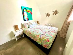 a bedroom with a bed and a painting on the wall at Dome by the sea in Trinity Beach