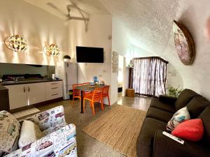 a living room with a couch and a table at Dome by the sea in Trinity Beach