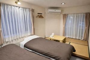 a bedroom with a bed and a table and windows at Ikoi in Nikko +79 photos