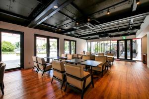 a dining room with tables and chairs and windows at HOTEL R9 Kujukuri "ex Casual Resort COFF Ichinomiya" in Ichinomiya