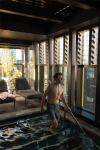 a man with a mop in a room at Quincy Hotel Melbourne in Melbourne