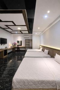 two beds in a hotel room with a tv at Miền Tây Hotel in Can Tho +67 photos
