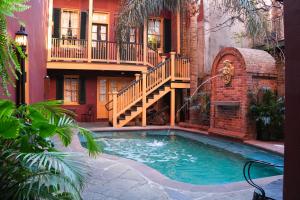 a swimming pool in front of a house with a staircase at The Olivier House Hotel in New Orleans
