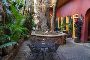 a table and chairs in a courtyard with a tree at The Olivier House Hotel in New Orleans