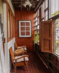 a porch of a house with chairs and windows at Baan Manee BKK in Bangkok