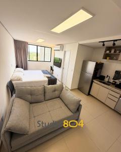 a bedroom with a bed and a couch and a kitchen at Studio Connect Life in Teresina +12 photos