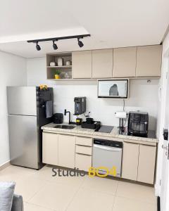 a kitchen with white cabinets and a refrigerator at Studio Connect Life in Teresina