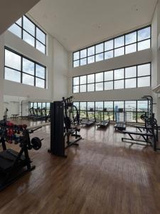 Ein Fitnessstudio mit Laufbändern und Geräten in einem Raum mit Fenstern in der Unterkunft Flat em Palmas no Vivence hotel in Palmas