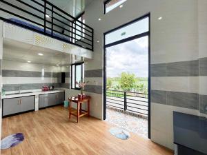 a kitchen with a large sliding glass door with a balcony at Homestay Phương Chi in Ấp Mỹ Phước