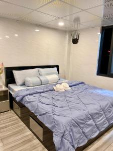 a bedroom with a large bed with a blue comforter at Homestay Phương Chi in Ấp Mỹ Phước