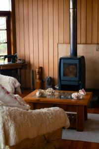 a living room with a wood stove and a table at Complejo Turistico Arena Gruesa in Ancud