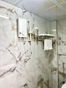 a shower in a bathroom with marble walls at Homestay Phương Chi in Ấp Mỹ Phước +140 photos