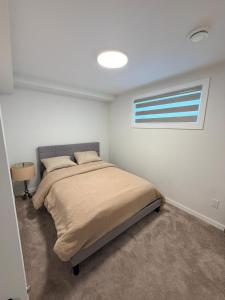 a bedroom with a bed and a window at Cozy and Stylish Private Basement Suite in Winnipeg