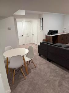 a living room with a table and a couch at Cozy and Stylish Private Basement Suite in Winnipeg