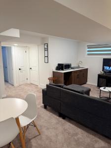 a living room with a couch and a tv at Cozy and Stylish Private Basement Suite in Winnipeg