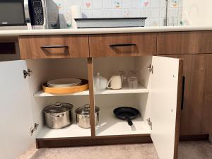 a kitchen with wooden cabinets with pots and pans at Cozy and Stylish Private Basement Suite in Winnipeg +23 photos