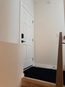 a room with a white door with a black mat at Cozy and Stylish Private Basement Suite in Winnipeg