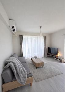 a living room with a couch and a table at Magokoro House 203 in Nishiizu