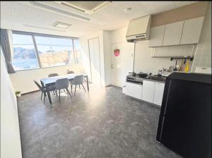 a kitchen with a table and chairs in a room at Magokoro House 203 in Nishiizu