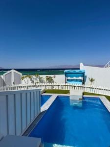 a swimming pool with a view of the ocean at ايارو نوب-iaru nub in Dahab