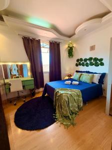 a bedroom with a blue bed and a desk at Suite casal 2 com frigobar in Belo Horizonte